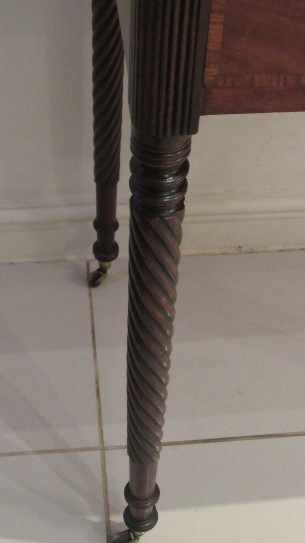 A Georgian mahogany chamber table featuring a rectangular top with a central flap, a single frieze drawer with brass hardware, and spiral turned legs on brass castors. View XI