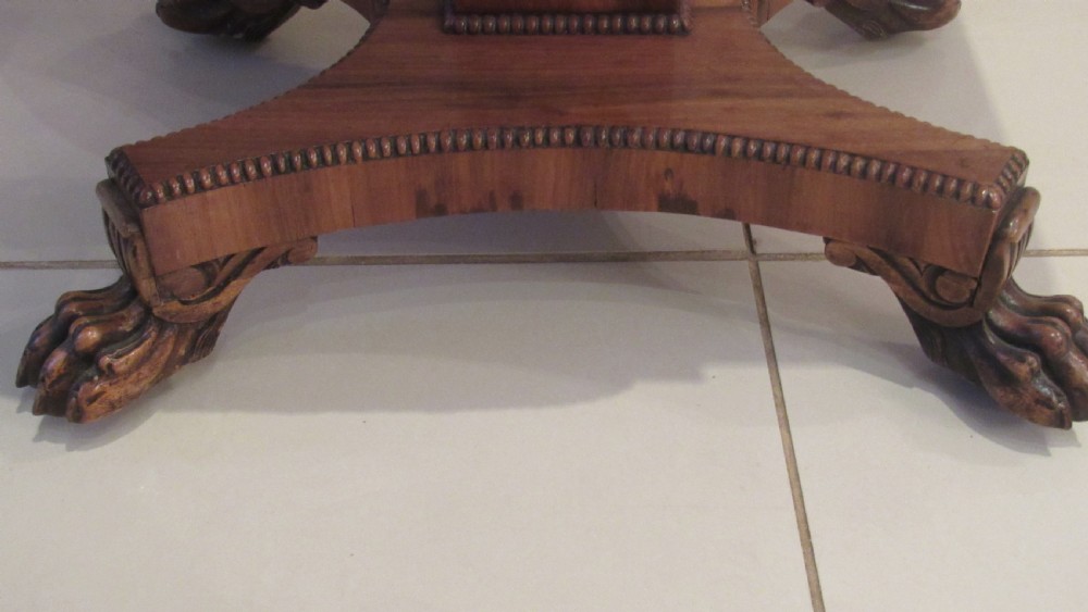 A William IV flame mahogany work table featuring drop-leaf side flaps, drawers with keyholes, a pleated pink fabric work well, and a quadruped base with carved paw feet. View VII