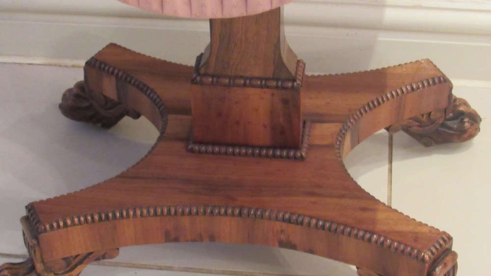 A William IV flame mahogany work table featuring drop-leaf side flaps, drawers with keyholes, a pleated pink fabric work well, and a quadruped base with carved paw feet. View XVI