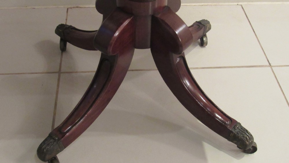 A Regency mahogany side table featuring a rectangular top with rounded corners, a central turned stem, and splayed legs with brass castors. View VI