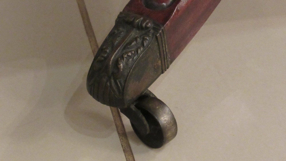 A Regency mahogany side table featuring a rectangular top with rounded corners, a central turned stem, and splayed legs with brass castors. View VII