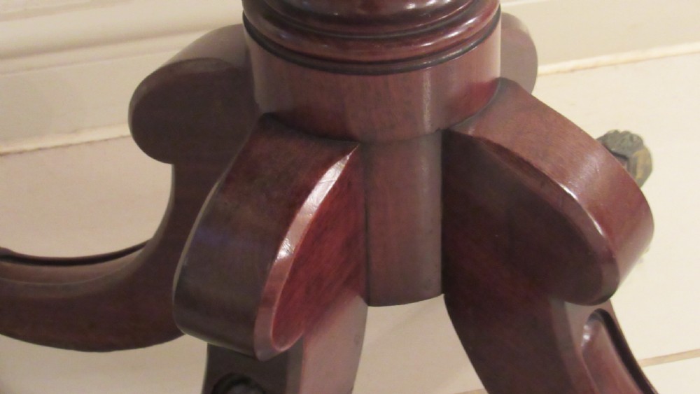 A Regency mahogany side table featuring a rectangular top with rounded corners, a central turned stem, and splayed legs with brass castors. View IX