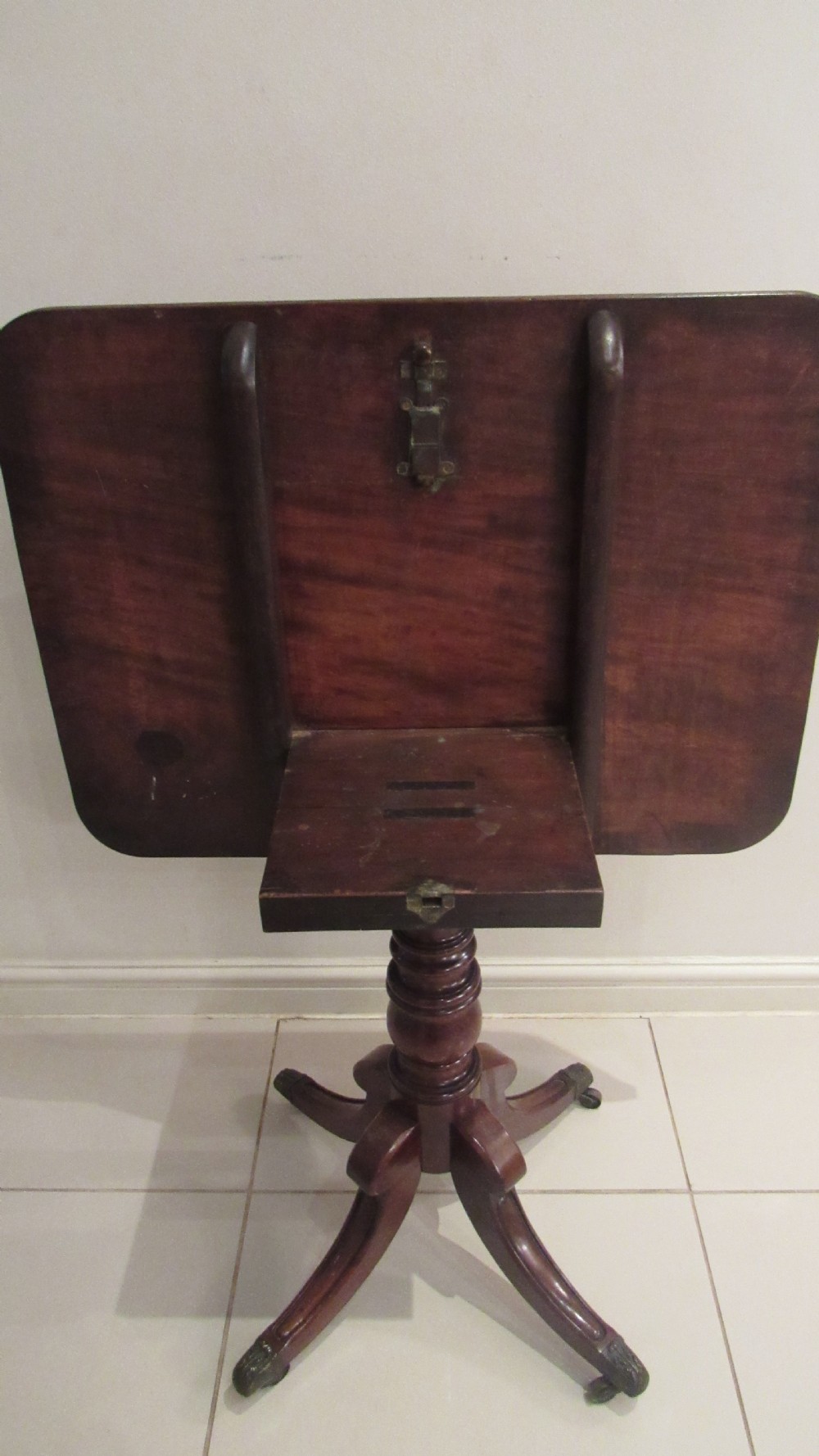 A Regency mahogany side table featuring a rectangular top with rounded corners, a central turned stem, and splayed legs with brass castors. View X