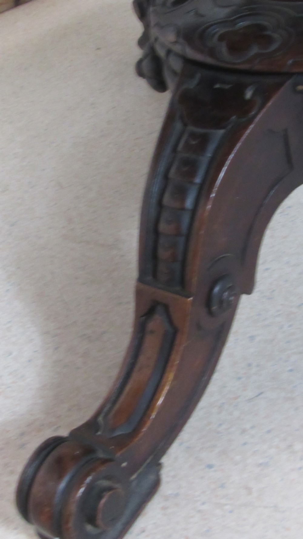 A 19th-century circular rosewood tilt-top table displayed in an upright position, featuring a shaped scalloped rim, prominent book-matched timber grain, and a carved pedestal base. View XII