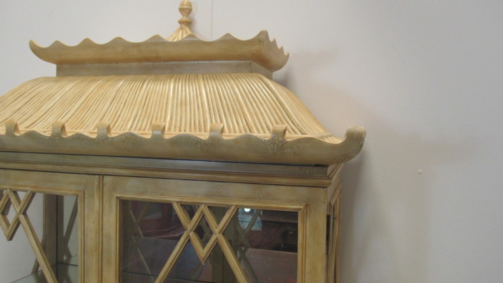 A cream painted Chinoiserie display cabinet on a stand featuring a pagoda-style roof, diamond lattice glass doors, and faux bamboo detailing. View X