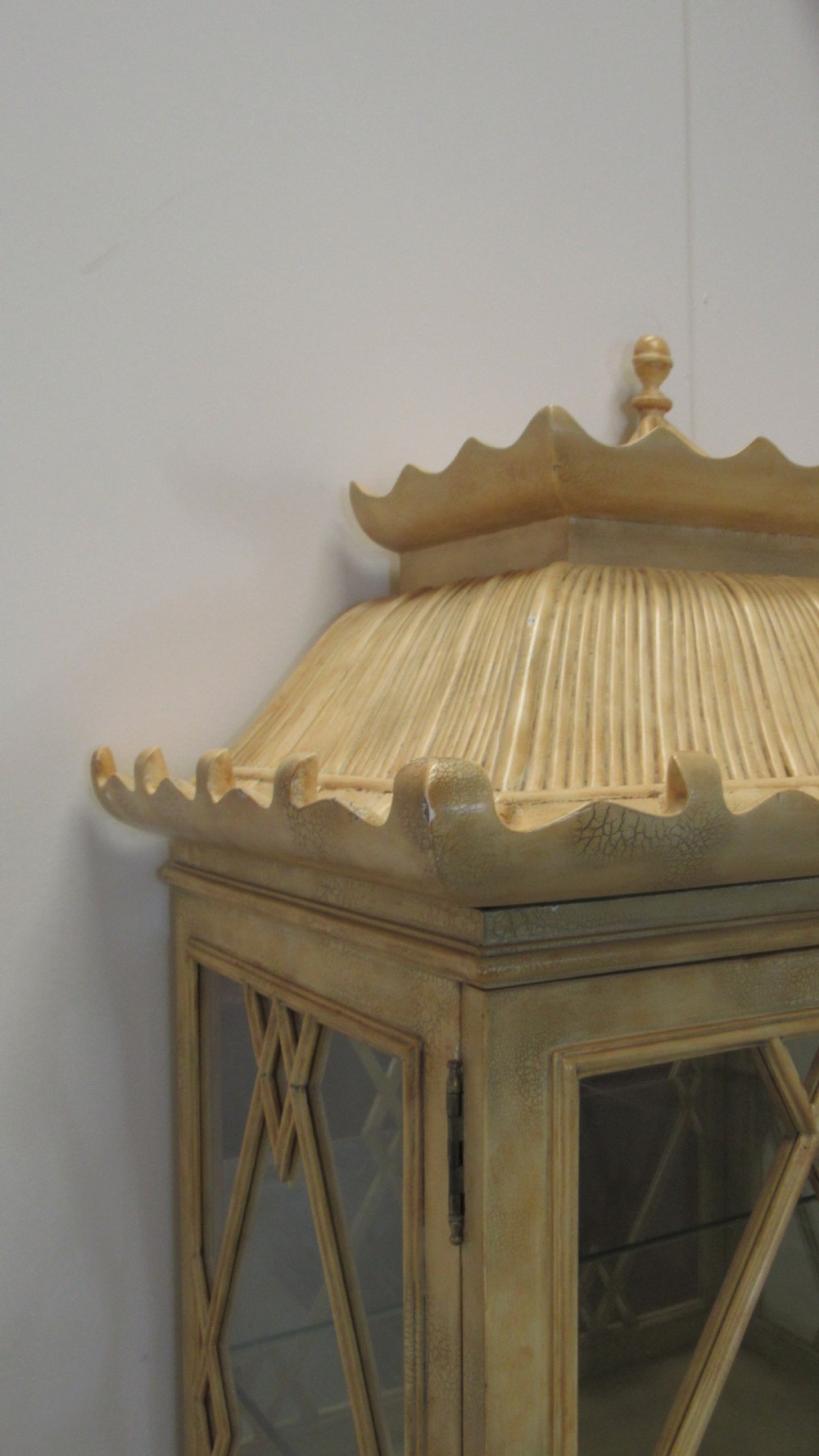 A cream painted Chinoiserie display cabinet on a stand featuring a pagoda-style roof, diamond lattice glass doors, and faux bamboo detailing. View XVI