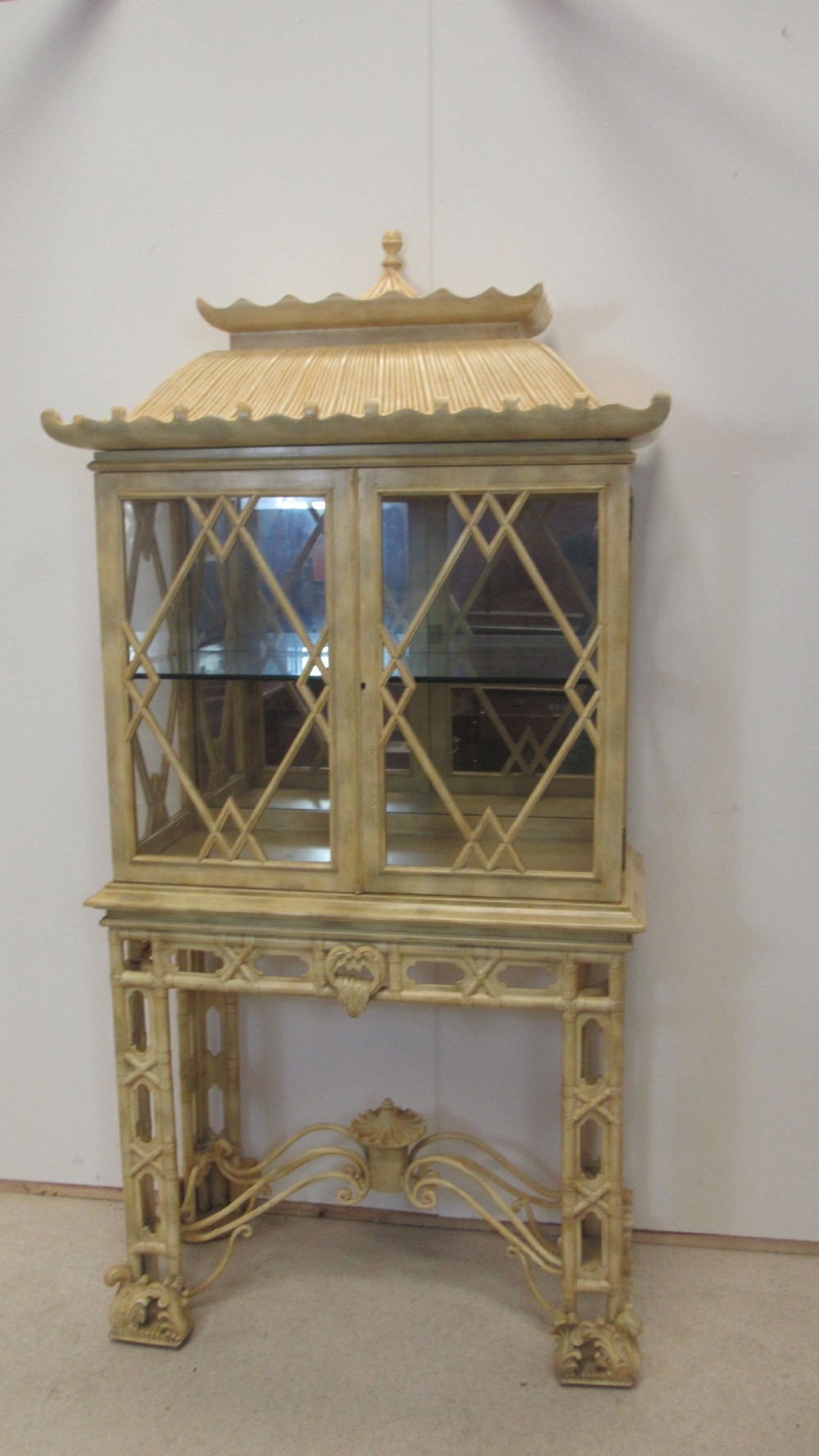 A cream painted Chinoiserie display cabinet on a stand featuring a pagoda-style roof, diamond lattice glass doors, and faux bamboo detailing. View XIX