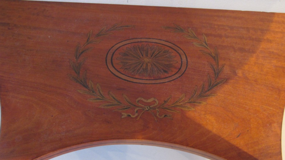 A semi-circular golden satinwood demilune console table featuring urn marquetry inlay, slender tapered legs, and an under-tier shelf. View V