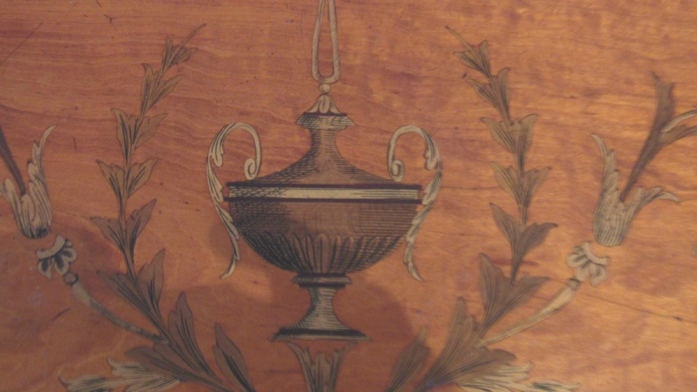 A semi-circular golden satinwood demilune console table featuring urn marquetry inlay, slender tapered legs, and an under-tier shelf. View VIII