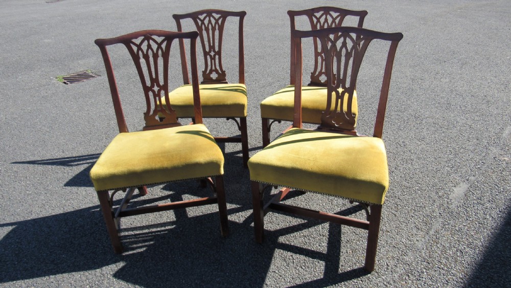 Set of four Georgian mahogany dining chairs featuring carved pierced splats and green velvet upholstered seats. View II