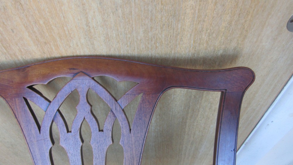 Set of four Georgian mahogany dining chairs featuring carved pierced splats and green velvet upholstered seats. View VI