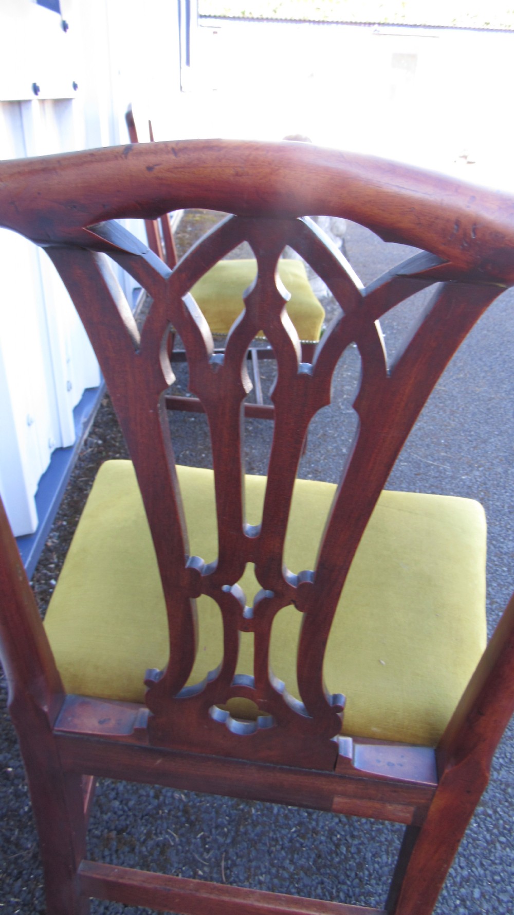 Set of four Georgian mahogany dining chairs featuring carved pierced splats and green velvet upholstered seats. View X