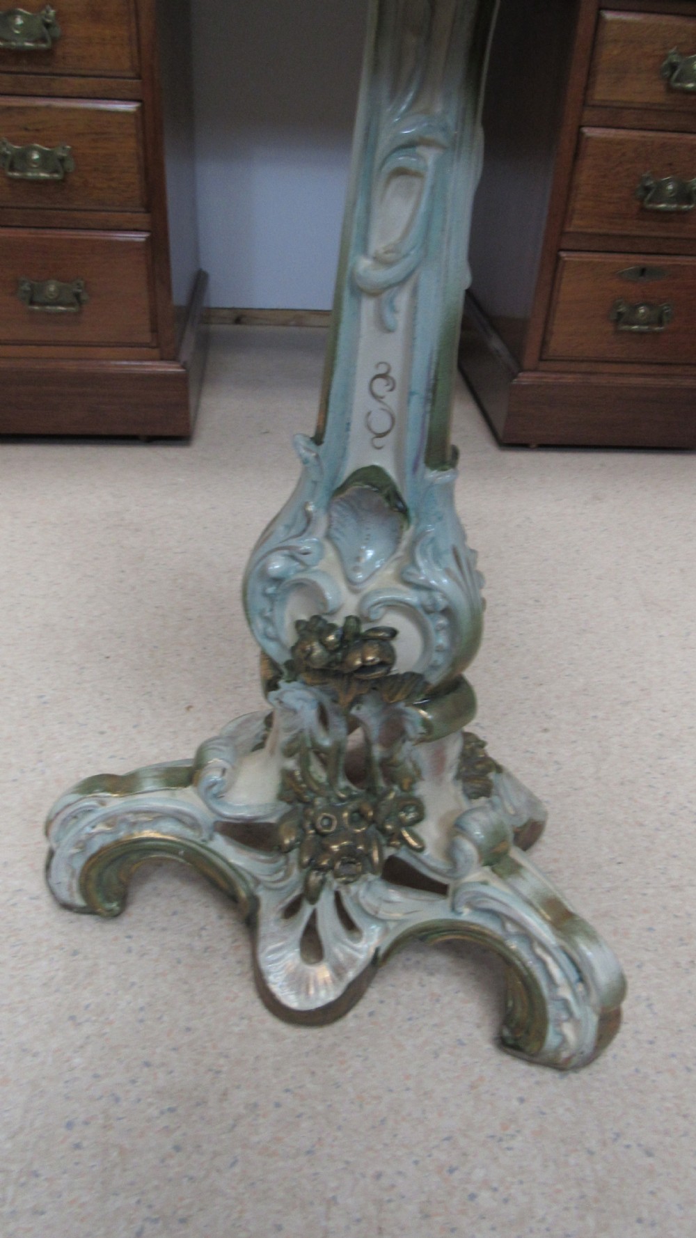 A circular Art Nouveau pottery table featuring a hand-painted floral iris design on a cream-glazed top supported by a sculpted pedestal base. View XI