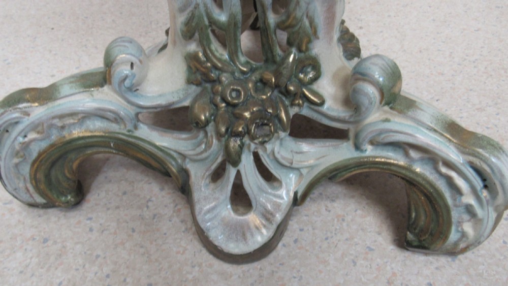 A circular Art Nouveau pottery table featuring a hand-painted floral iris design on a cream-glazed top supported by a sculpted pedestal base. View XIII