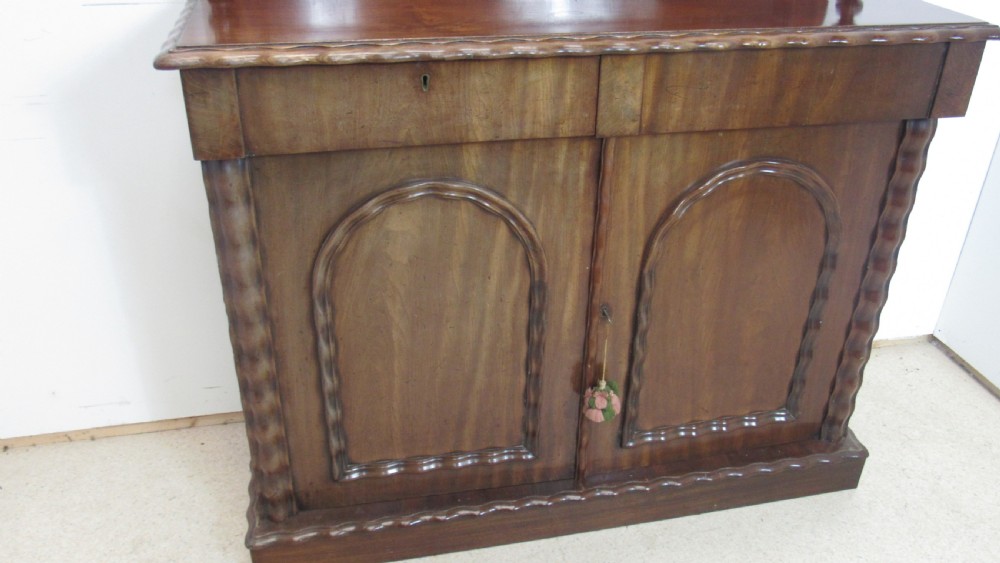 A Victorian mahogany chiffonier featuring an upper gallery shelf with turned side supports above a two-door lower cabinet with arched moulded panels. View II