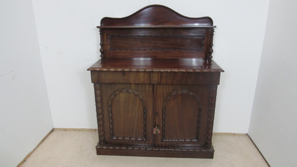 A Victorian mahogany chiffonier featuring an upper gallery shelf with turned side supports above a two-door lower cabinet with arched moulded panels. View III