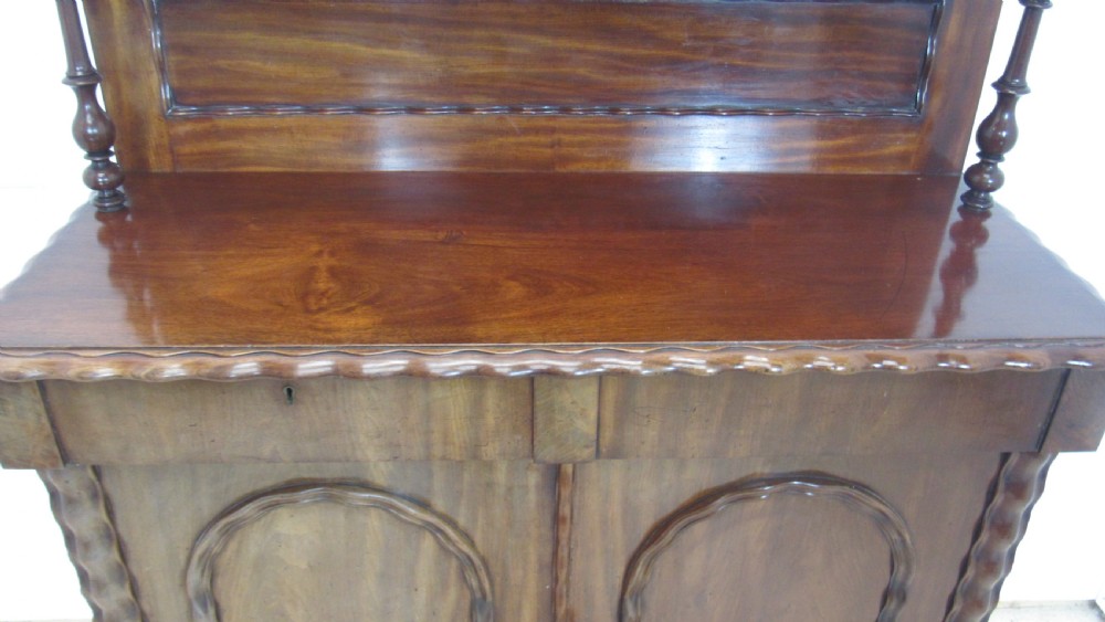 A Victorian mahogany chiffonier featuring an upper gallery shelf with turned side supports above a two-door lower cabinet with arched moulded panels. View VI
