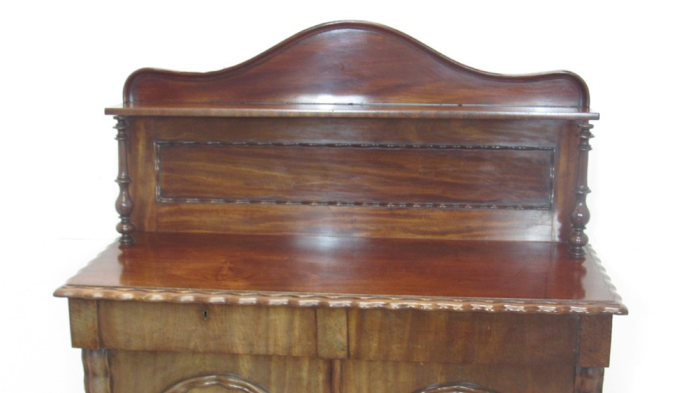 A Victorian mahogany chiffonier featuring an upper gallery shelf with turned side supports above a two-door lower cabinet with arched moulded panels. View IX