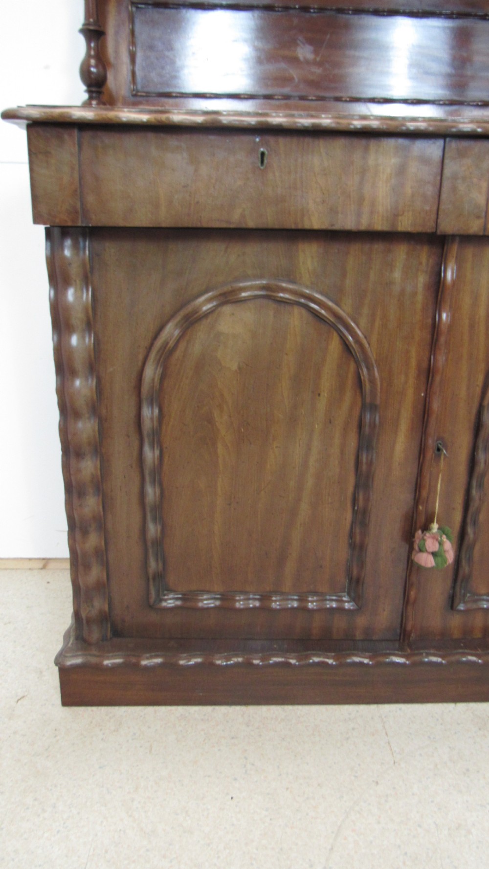 A Victorian mahogany chiffonier featuring an upper gallery shelf with turned side supports above a two-door lower cabinet with arched moulded panels. View XI