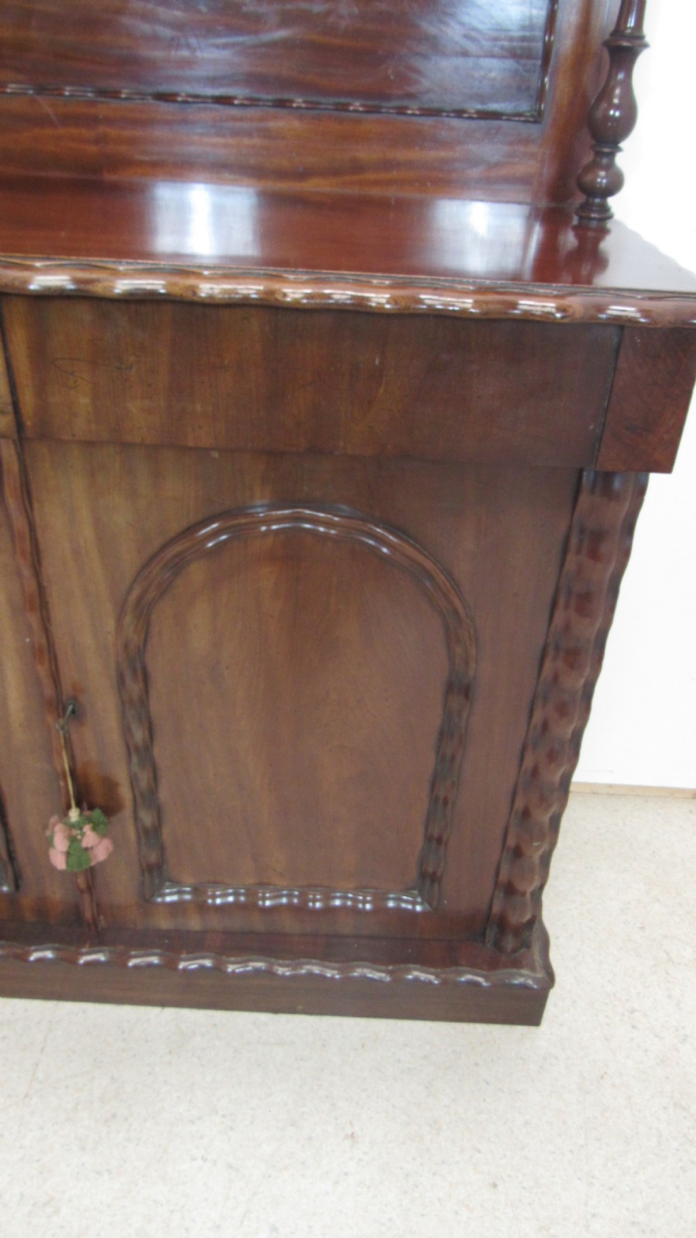 A Victorian mahogany chiffonier featuring an upper gallery shelf with turned side supports above a two-door lower cabinet with arched moulded panels. View XV