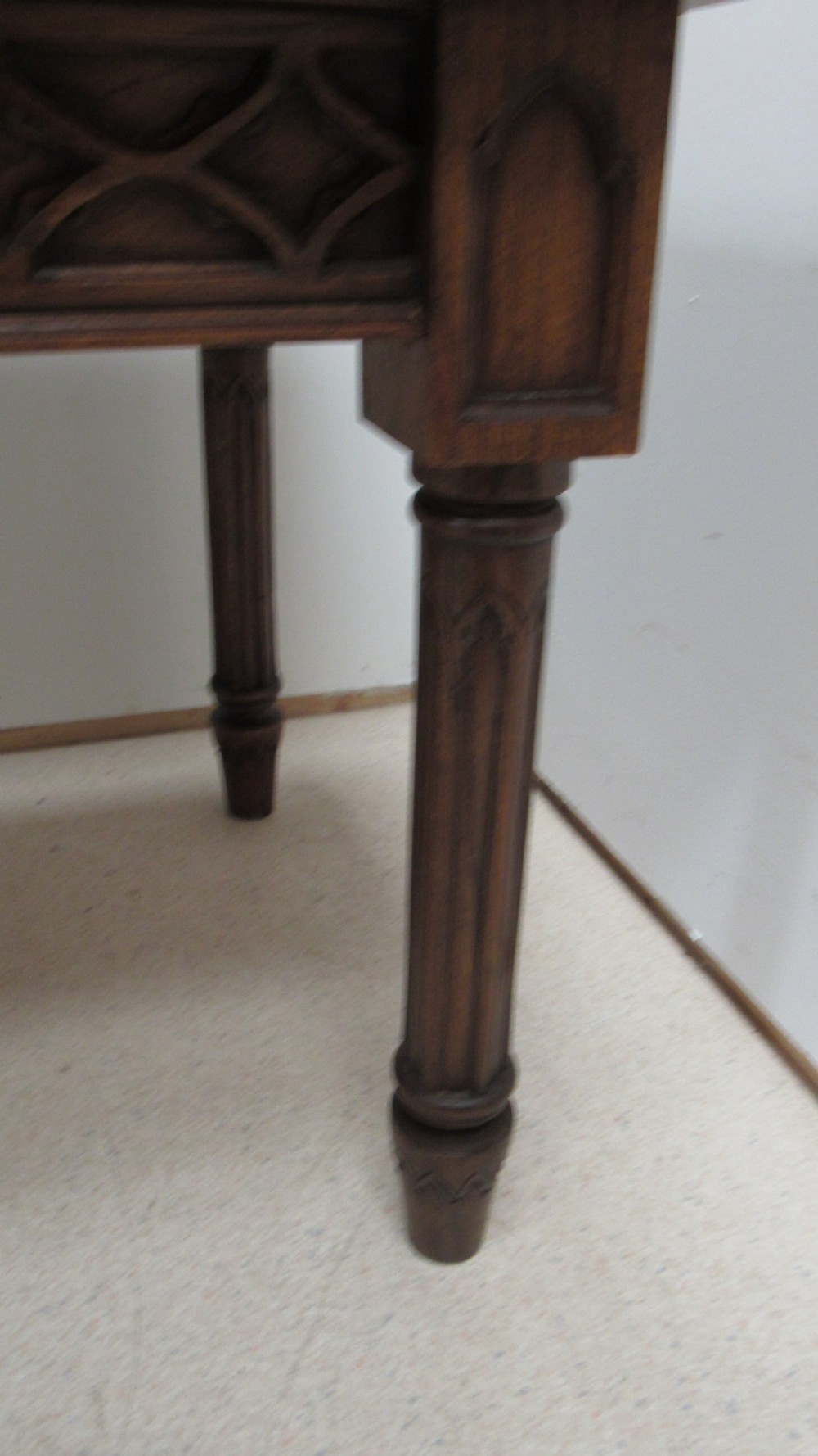 A rectangular solid oak refectory table featuring carved Gothic blind tracery along the frieze and turned column legs. View IV