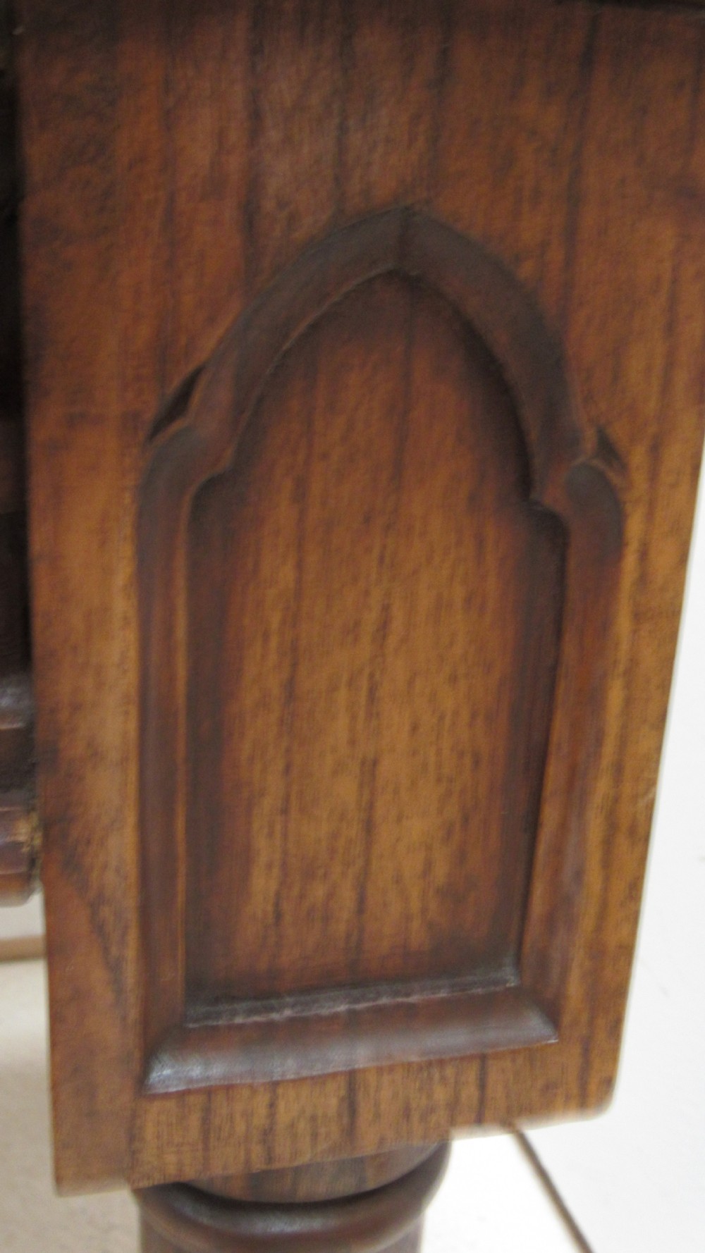 A rectangular solid oak refectory table featuring carved Gothic blind tracery along the frieze and turned column legs. View VI