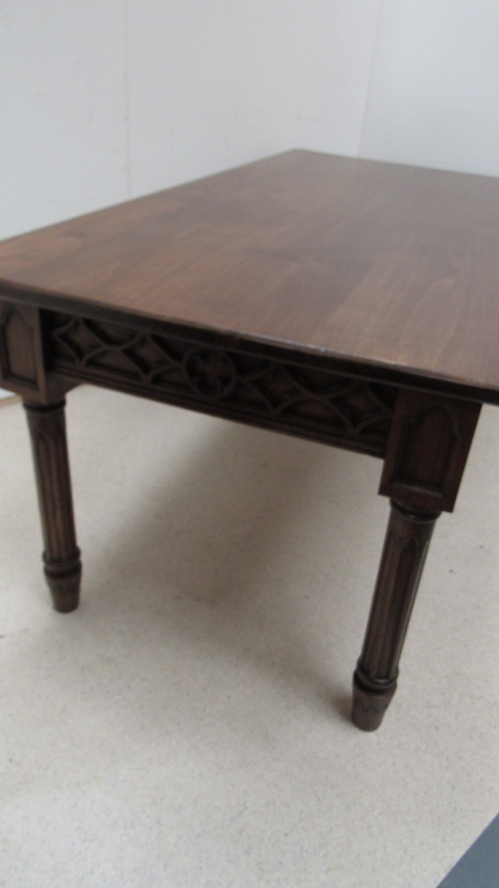 A rectangular solid oak refectory table featuring carved Gothic blind tracery along the frieze and turned column legs. View X