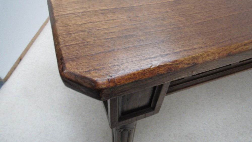 A rectangular solid oak refectory table featuring carved Gothic blind tracery along the frieze and turned column legs. View XIV