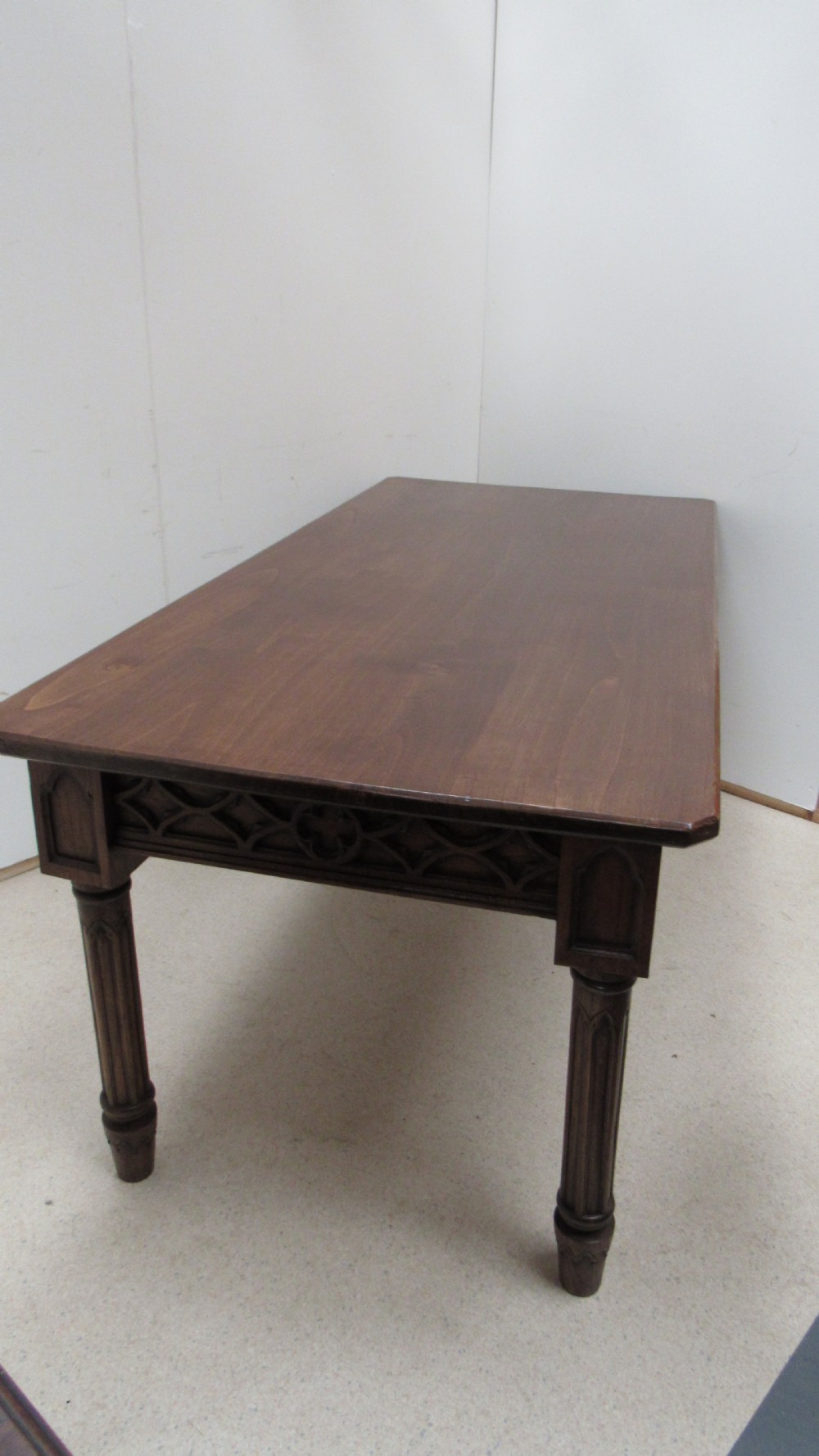 A rectangular solid oak refectory table featuring carved Gothic blind tracery along the frieze and turned column legs. View XIX