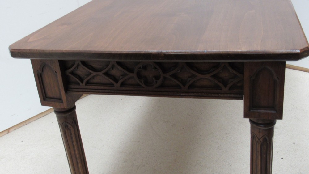 A rectangular solid oak refectory table featuring carved Gothic blind tracery along the frieze and turned column legs. View XX