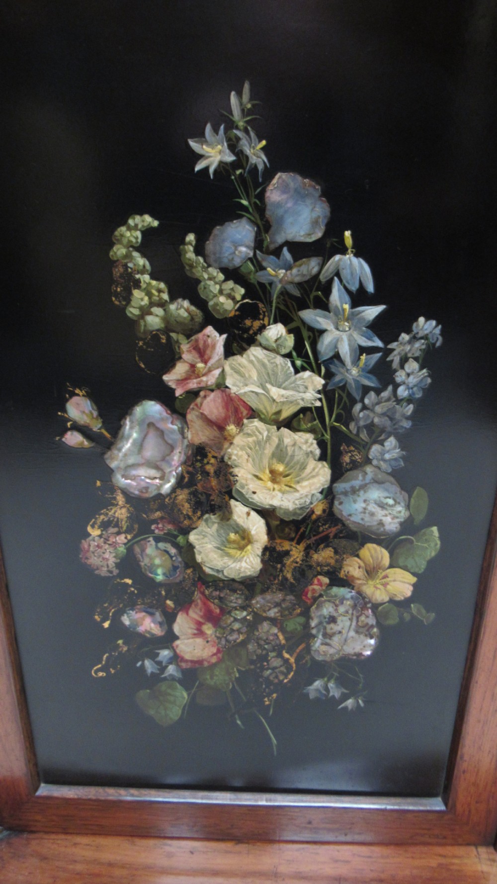 A nineteenth-century dark wood side cabinet featuring two central black door panels decorated with floral arrangements, framed by carved scroll supports and curved pleated side sections. View IV
