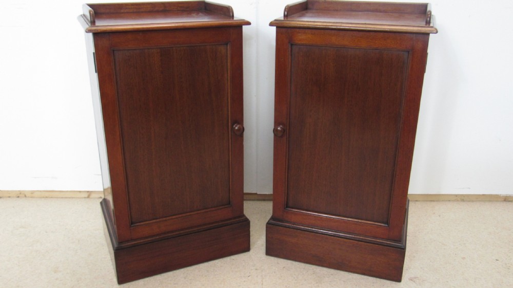 A pair of antique mahogany pot cupboards featuring three-sided gallery tops, single panelled doors with wooden knobs, and solid plinth bases. View III