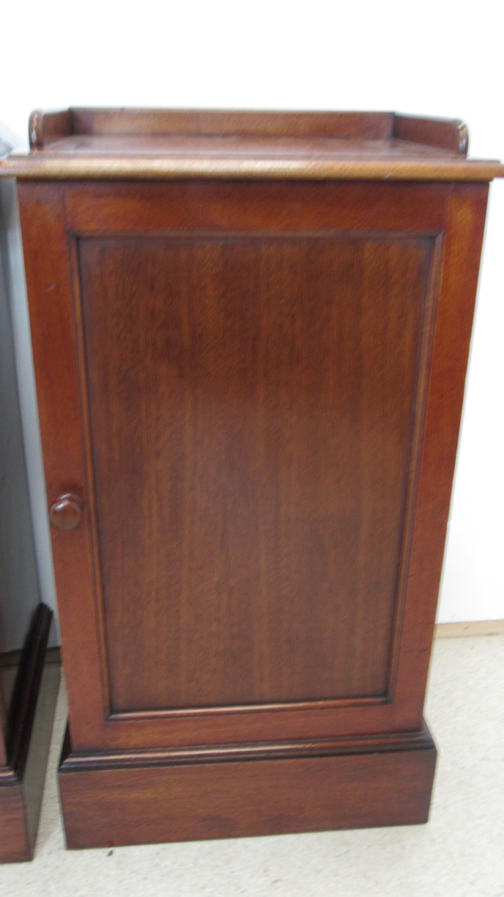 A pair of antique mahogany pot cupboards featuring three-sided gallery tops, single panelled doors with wooden knobs, and solid plinth bases. View IV