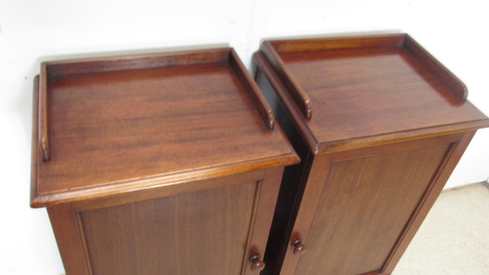 A pair of antique mahogany pot cupboards featuring three-sided gallery tops, single panelled doors with wooden knobs, and solid plinth bases. View VIII