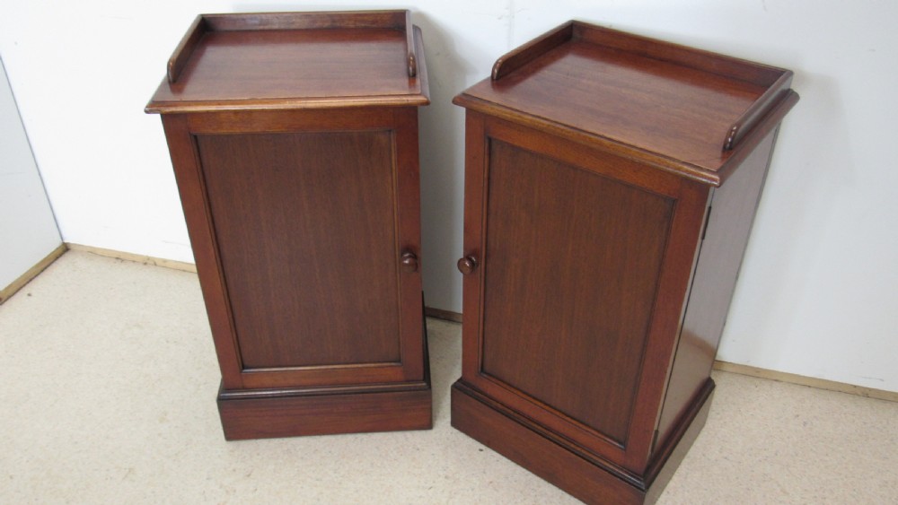 A pair of antique mahogany pot cupboards featuring three-sided gallery tops, single panelled doors with wooden knobs, and solid plinth bases. View XI
