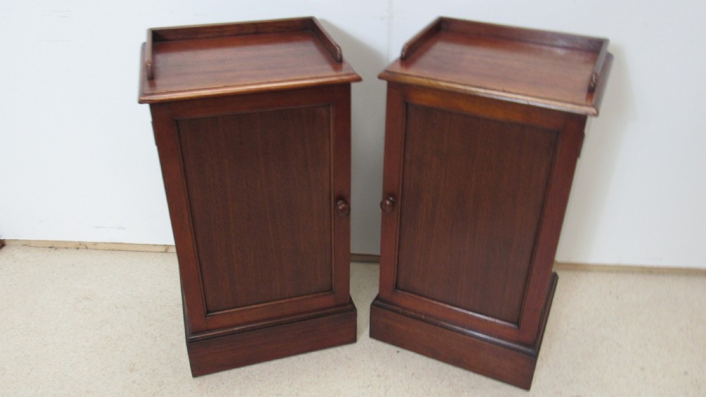 A pair of antique mahogany pot cupboards featuring three-sided gallery tops, single panelled doors with wooden knobs, and solid plinth bases. View XII