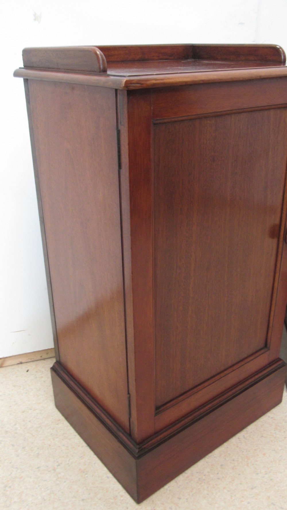 A pair of antique mahogany pot cupboards featuring three-sided gallery tops, single panelled doors with wooden knobs, and solid plinth bases. View XIII