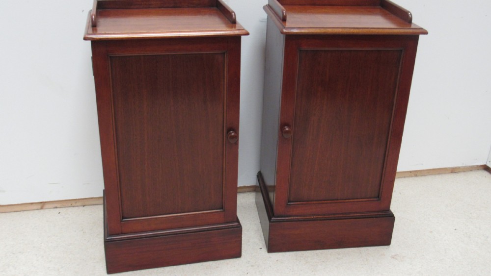 A pair of antique mahogany pot cupboards featuring three-sided gallery tops, single panelled doors with wooden knobs, and solid plinth bases. View XVII