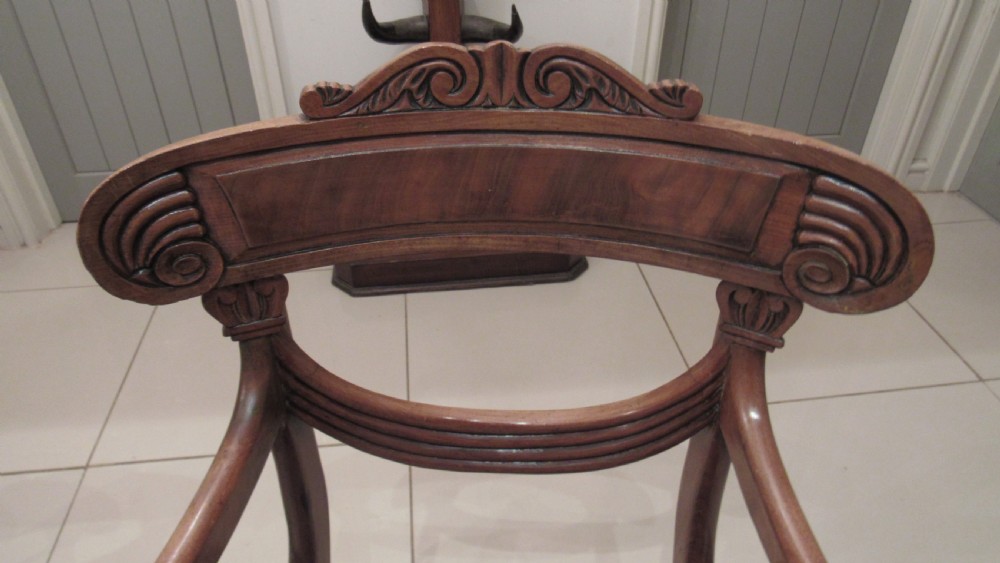 Pair of Regency mahogany carver chairs featuring curved scroll arms, reeded front legs, and patterned fabric seat upholstery. View II
