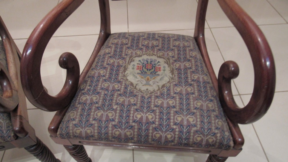 Pair of Regency mahogany carver chairs featuring curved scroll arms, reeded front legs, and patterned fabric seat upholstery. View V