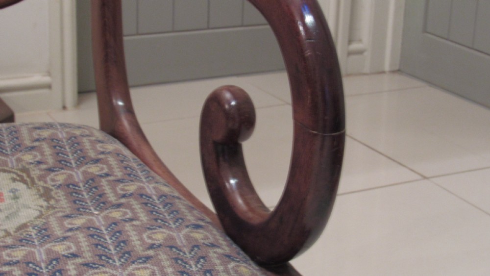 Pair of Regency mahogany carver chairs featuring curved scroll arms, reeded front legs, and patterned fabric seat upholstery. View IX