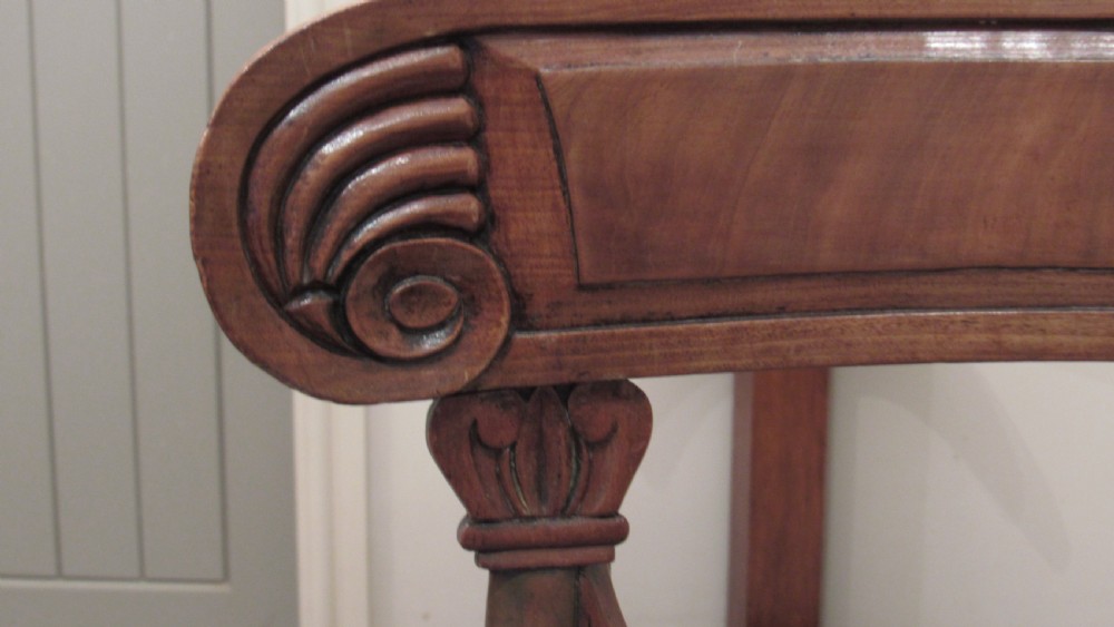 Pair of Regency mahogany carver chairs featuring curved scroll arms, reeded front legs, and patterned fabric seat upholstery. View X