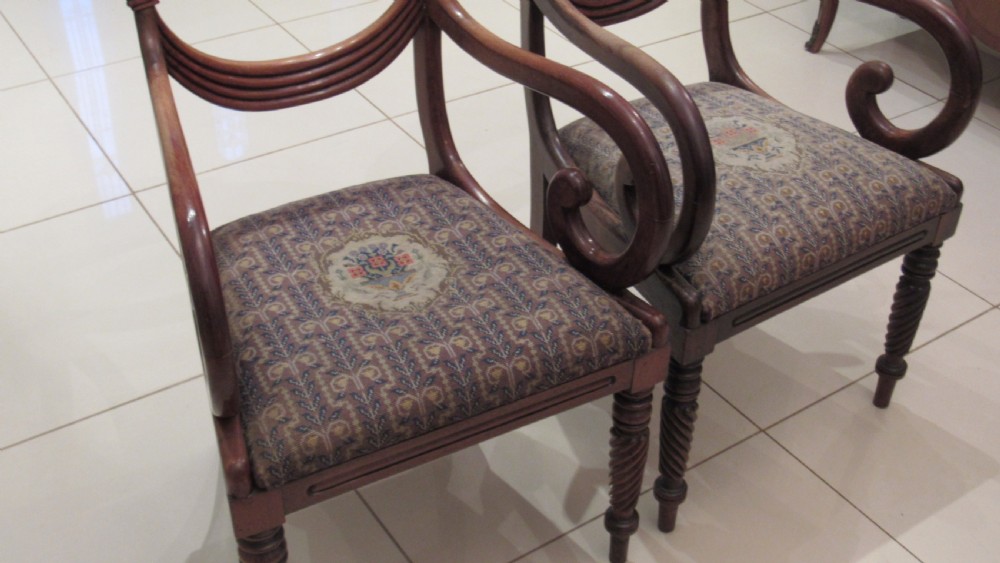Pair of Regency mahogany carver chairs featuring curved scroll arms, reeded front legs, and patterned fabric seat upholstery. View XVII
