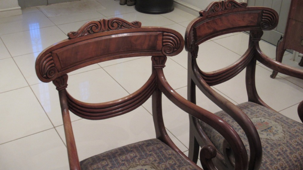 Pair of Regency mahogany carver chairs featuring curved scroll arms, reeded front legs, and patterned fabric seat upholstery. View XVIII