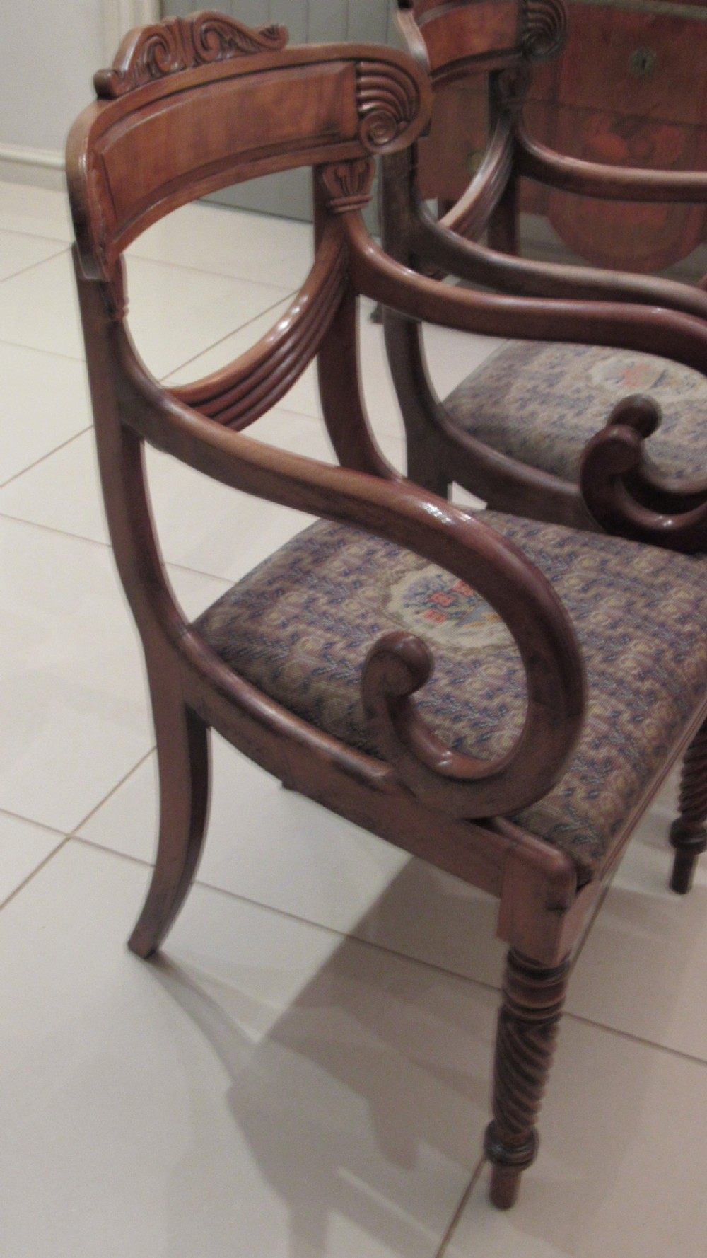 Pair of Regency mahogany carver chairs featuring curved scroll arms, reeded front legs, and patterned fabric seat upholstery. View XIX