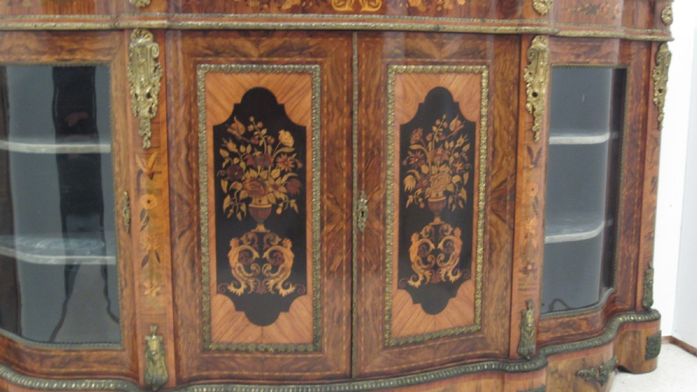 A Victorian serpentine-front credenza featuring central floral marquetry doors, glass display side cupboards, and ornate gilt-bronze mounts. View II
