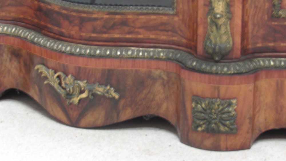 A Victorian serpentine-front credenza featuring central floral marquetry doors, glass display side cupboards, and ornate gilt-bronze mounts. View V