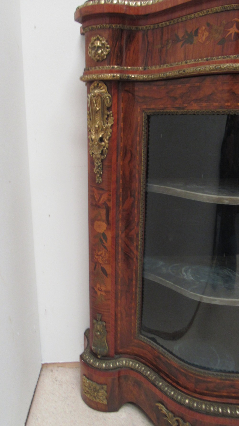 A Victorian serpentine-front credenza featuring central floral marquetry doors, glass display side cupboards, and ornate gilt-bronze mounts. View VIII