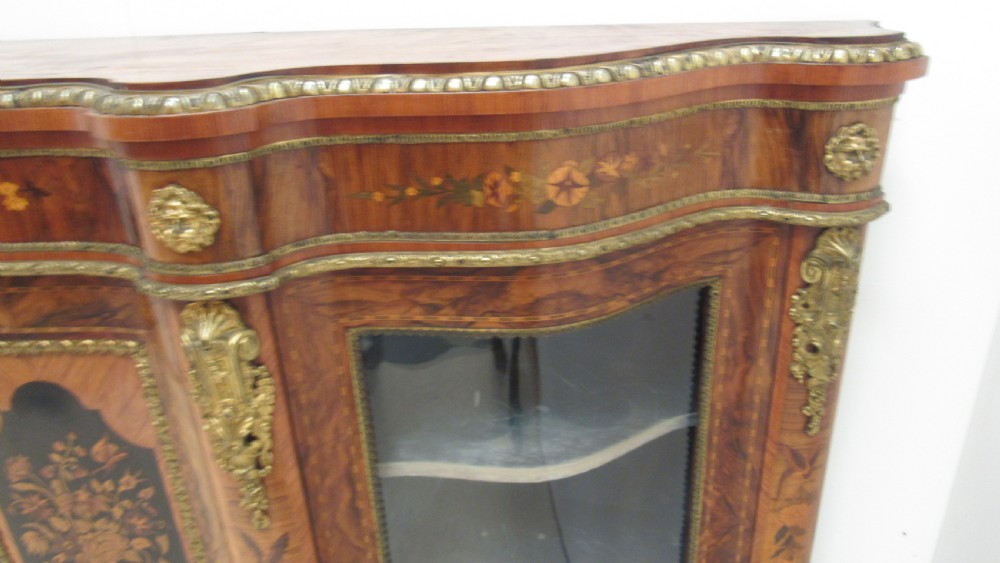 A Victorian serpentine-front credenza featuring central floral marquetry doors, glass display side cupboards, and ornate gilt-bronze mounts. View XIV