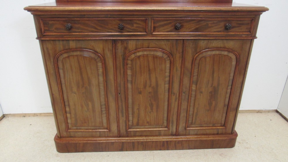 A Victorian mahogany side cabinet with a low rear gallery, two upper drawers, and three arched panel cupboard doors set on a plinth base. View XII